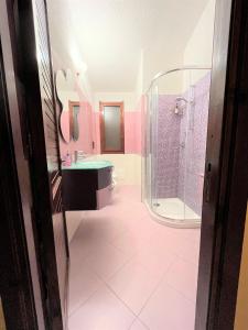 杰若米斯Villa Fiorilla的粉红色的浴室设有淋浴和水槽