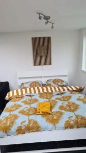 瓦瑟纳尔Tiny house Wassenaar的一间卧室,床上有黄色衬衫