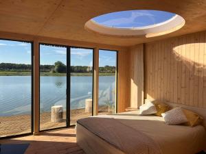 希迈Aquascope Virelles - Logements insolites的一间卧室配有一张床,享有水景