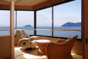 长滨市红鲇日式旅馆的客房设有带椅子和桌子的大窗户。