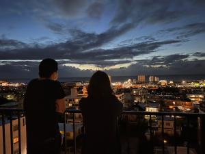 宜野湾市THE GRAND HOTEL GINOWAN的夜视城市的情侣