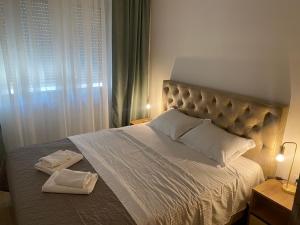 布德瓦Solaris Apartments的一间卧室配有一张大床和两条毛巾