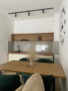 布德瓦Solaris Apartments的一间带木桌和绿色椅子的用餐室
