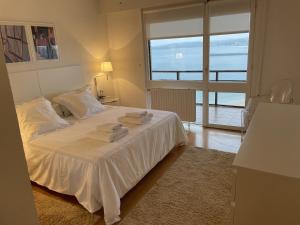 宏达瑞比亚Iturrain by smiling rentals的卧室配有白色床和毛巾