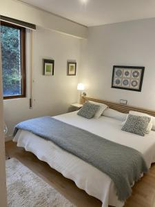 宏达瑞比亚Iturrain by smiling rentals的卧室配有一张带两个枕头的大白色床