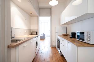 南希L'Annexe de Stanislas的厨房铺有木地板,配有白色橱柜。