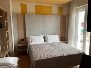 西尔米奥奈罗莎别墅酒店的卧室配有带白色枕头的床和窗户。