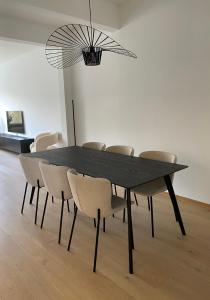 莫尔特塞尔Cosy Apartment near Antwerp的黑色餐桌,配有椅子和吊灯