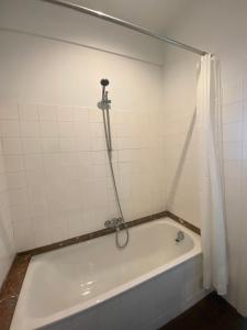莫尔特塞尔Cosy Apartment near Antwerp的浴室内设有带浴帘的白色浴缸
