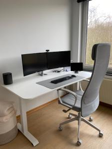 莫尔特塞尔Cosy Apartment near Antwerp的一张带电脑显示器和椅子的白色书桌