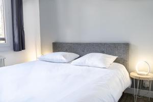 莱索尔Les Anémones 6 places的卧室配有白色的床和2个枕头