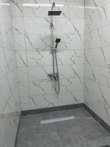 阿拉木图Tastaq hostel的带淋浴的浴室,拥有白色的大理石墙壁
