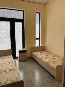 阿拉木图Tastaq hostel的带2扇窗户的客房内的2张床