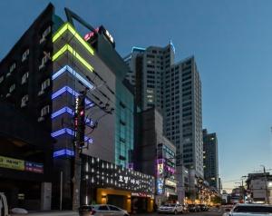 蔚山Hotel H2的一条城市街道,有高高的建筑和交通灯