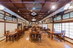 箱根伊其挪揄宏坎酒店的一间空餐厅,配有木桌和椅子