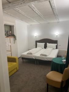 巴克乌Sport Residence的一间卧室配有一张床和一张黄色椅子