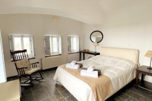 马拉松TΟRRE DI PIETRA-LUXURY RESIDENCE-ΑMAZING SEA VIEW的一间卧室配有一张床、一把椅子和镜子