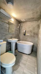礁溪漫旅溫泉會館-愛娜的浴室配有卫生间、浴缸和水槽。