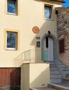 ArceviaLa casa di Mastro Ivetto的房屋设有通往前门的楼梯