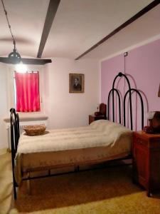 ArceviaLa casa di Mastro Ivetto的一间卧室配有一张带金属框架的床和窗户