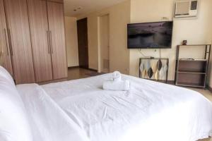 马尼拉Cozy 2-bedroom in The Venice Luxury Residences的一张白色的大床,上面有一条毛巾