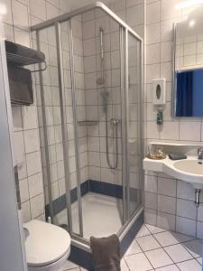 施坦贝尔格湖畔贝格Strandhotel Berg的带淋浴、卫生间和盥洗盆的浴室