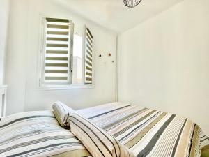 普罗普里亚诺U Paradisu - Balcon - 100m mer - Parking - Climatisation的白色客房的一张床位,设有窗户