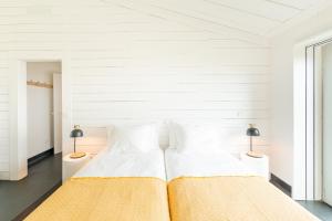 Companhia de BaixoCasas da Prainha C的一间白色卧室,配有两张床和两盏灯。