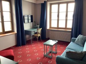 施坦贝尔格湖畔贝格Strandhotel Berg的客厅配有书桌和沙发。