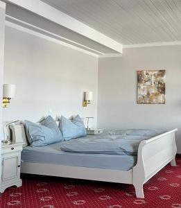 施坦贝尔格湖畔贝格Strandhotel Berg的一间卧室配有一张带蓝色枕头的大床