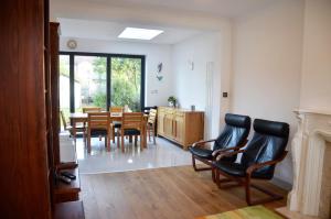 雷德布里奇5 bedroom sunlit family house with garden的客厅设有餐桌和椅子