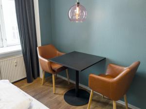哥本哈根where to sleep的一间设有黑桌子和两把椅子的房间