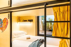 马德里Petit Hostel Palacio Real的一间卧室设有两张双层床,配有黄色窗帘