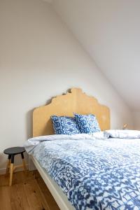 布鲁日3 Queens的一间卧室配有一张带蓝白色床单的大床