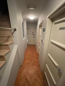 奥西耶克Perla Inn的走廊设有门、木地板和楼梯