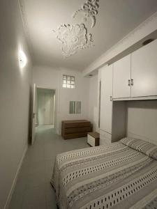雷卡纳蒂港La Rondine rental apartment的白色卧室配有一张大床和吊灯