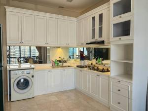 雅加达Senopati Penthouse Luxury 2 Bedroom Full Furnished SCBD Area的厨房配有白色橱柜和洗衣机。