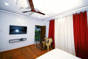 埃尔加德GV Resort的一间卧室配有一张床、一台电视和一张桌子