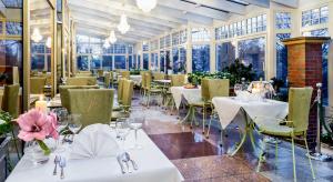 弗罗茨瓦夫加纳帕拉二世国王酒店的餐厅设有白色的桌椅和窗户。