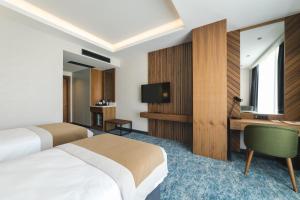 波德戈里察Bristol Hotel Podgorica的酒店客房配有两张床和一张书桌