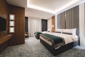 波德戈里察Bristol Hotel Podgorica的酒店客房设有两张床和电视。