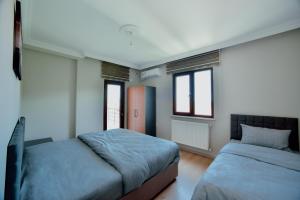 AkçatepeEMİSSA MOTEL的一间卧室设有两张床和两个窗户。