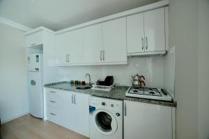 AkçatepeEMİSSA MOTEL的厨房配有白色橱柜、洗衣机和烘干机