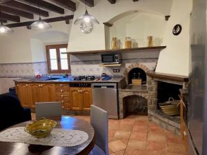 贝尔达Can Homs的厨房设有壁炉、餐桌和用餐室
