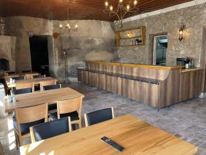 格雷梅萨克斯甘岩洞酒店的一间带木桌的餐厅和一间酒吧