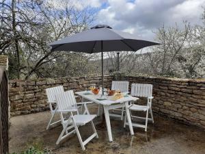 Chassey-le-CampMaison rénovée sur domaine viticole Renovated old house on wine estate的一张白色的桌子和椅子,配有雨伞