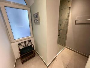 直布罗陀Stylish 2BR contemporary design perfect vacation的带淋浴、窗户和椅子的浴室