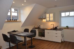 Rehburg-LoccumRehburger Landhaus的厨房配有白色橱柜和桌椅
