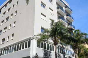 布林迪西Casa Ferretti apartment的一座白色的建筑,前面有棕榈树