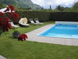 梅拉诺Garni Unterhaslerhof的一个带躺椅的庭院内的游泳池